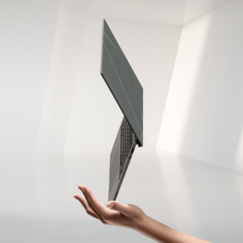 Zenbook S 13 OLED floating in the palm of a hand standing on its corner with an EVO badge by its side.