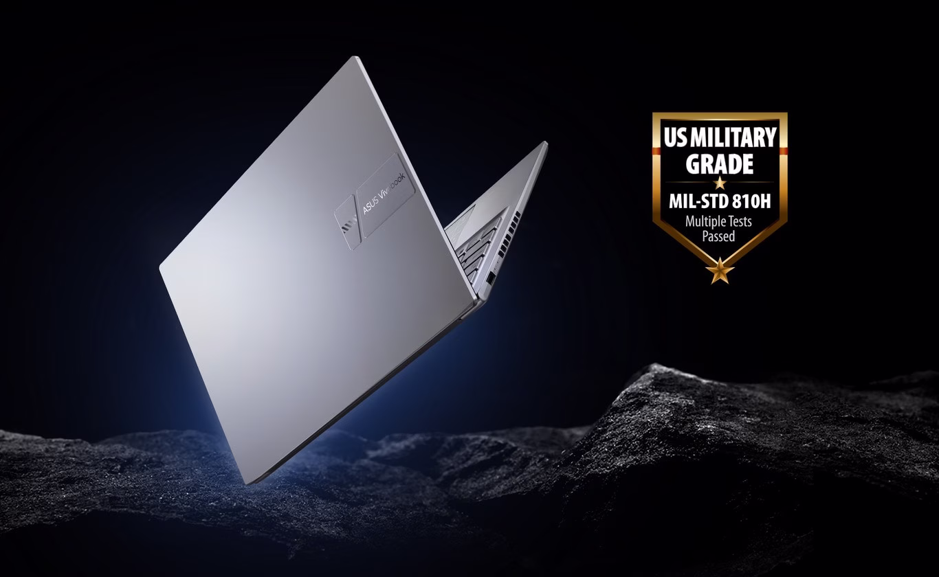 S&oslash;lvfarvet ASUS Vivobook-b&aelig;rbar computer vises i en vinkel, sv&aelig;vende over en struktureret sort overflade.