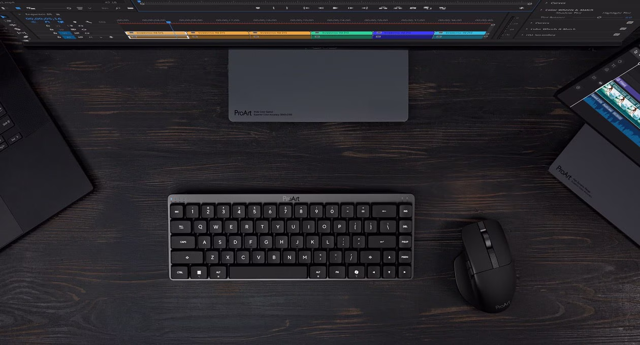 A workstation setup showing ProArt Mouse MD301, ProArt Keyboard, two displays, and a laptop.