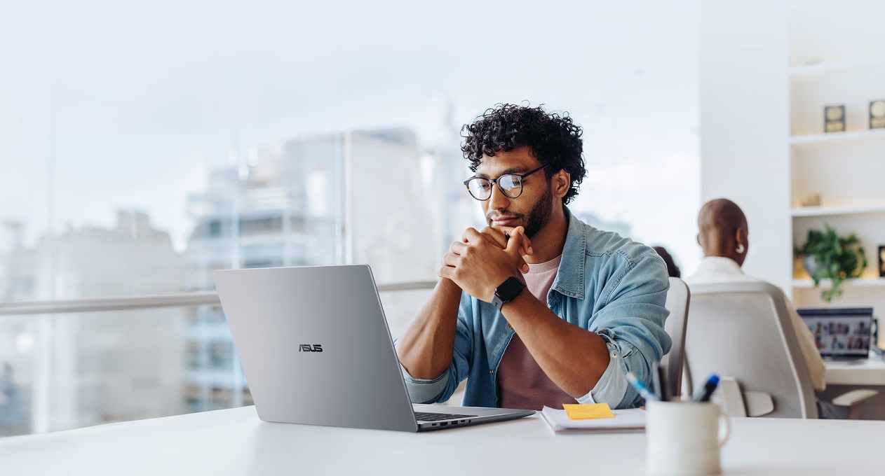An office shows a man working at her desk with an ASUS ExpertBook P5 G2.