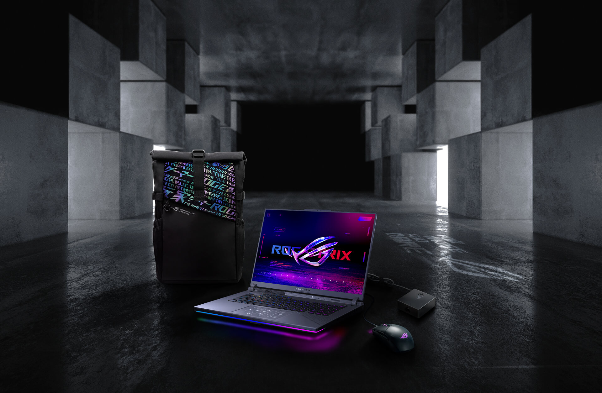 In an underground big space, from left to right; an ROG backpack, G16, ROG Strix Gladius III mouse, and 100W adapter.