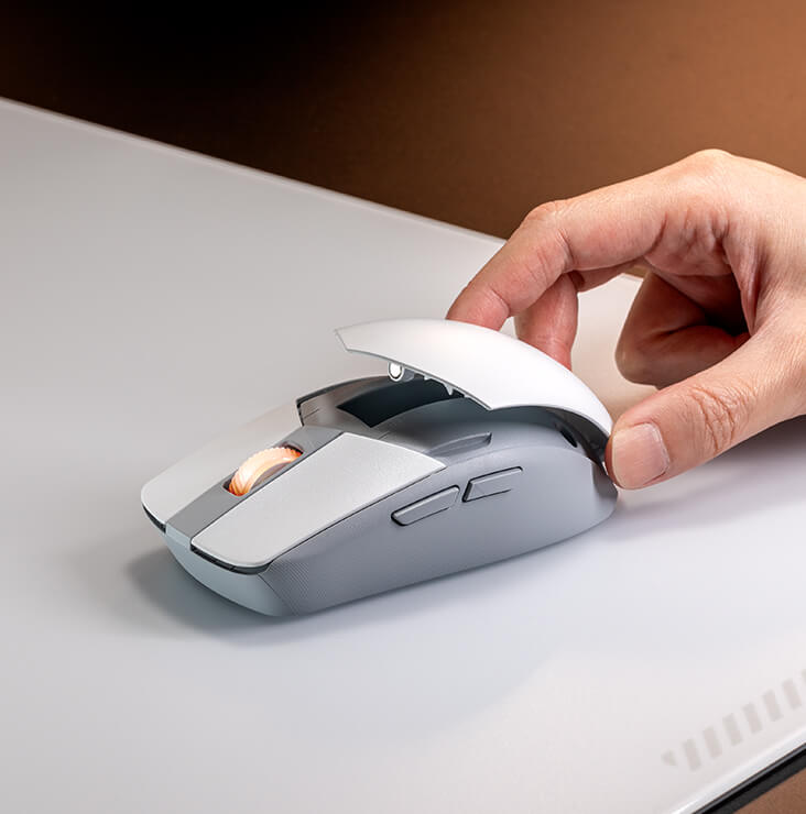 A hand removing the back magnetic lid of the Strix Impact III Wireless to show its magnetic lid for easy battery swapping