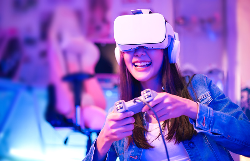 Gamer playing a console game with a controller and headset on a desktop monitor.