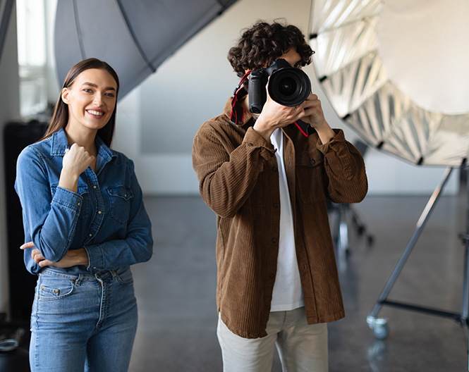 Um homem est&aacute; a tirar uma fotografia com uma mulher num est&uacute;dio.