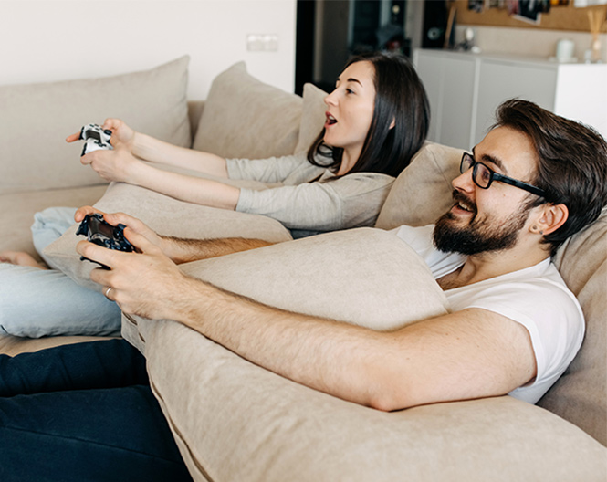 Um homem e uma mulher a jogar no sof&aacute;.