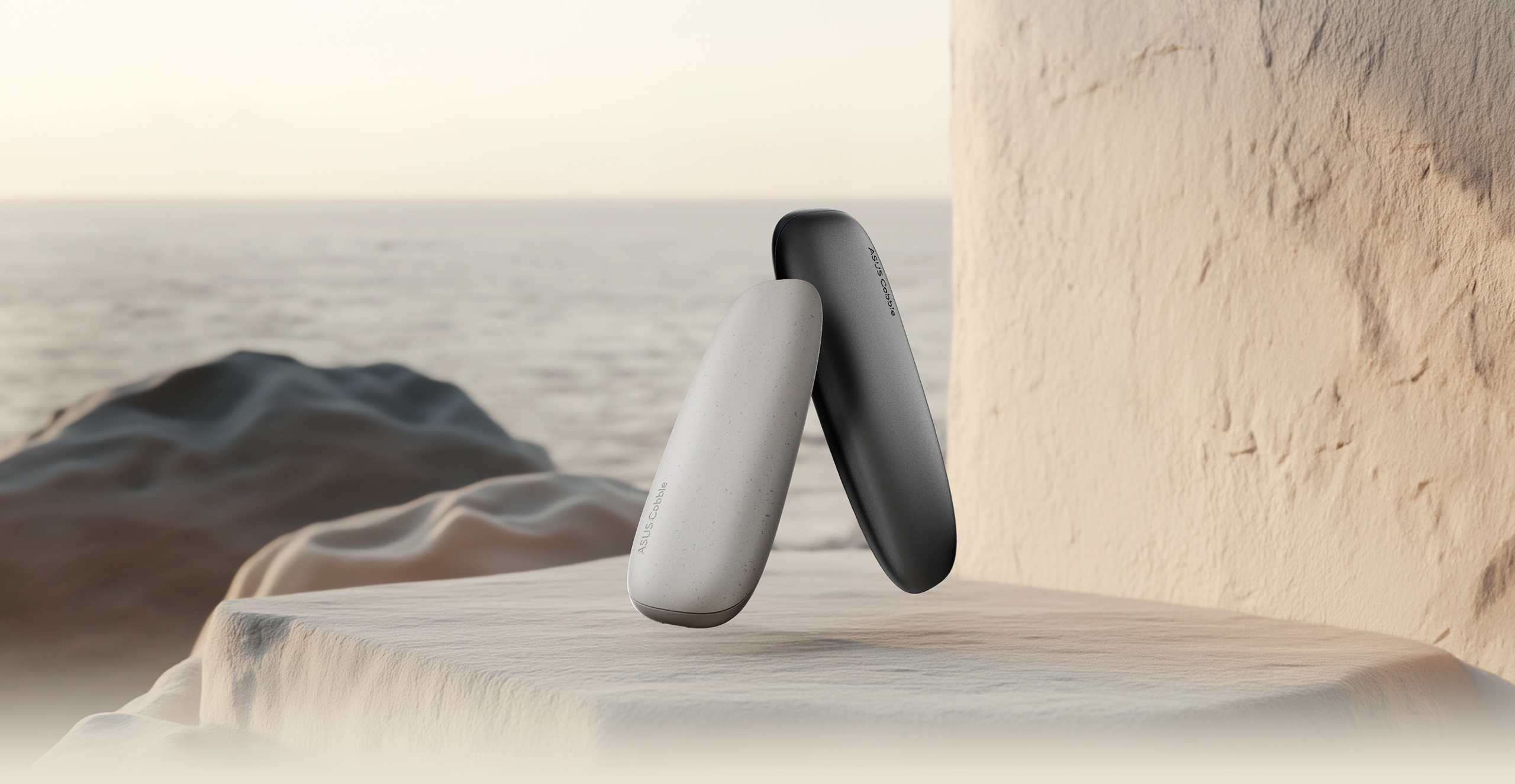 Duas Caixas ASUS Cobble numa vista angular com um cen&aacute;rio de uma costa rochosa e um vasto oceano