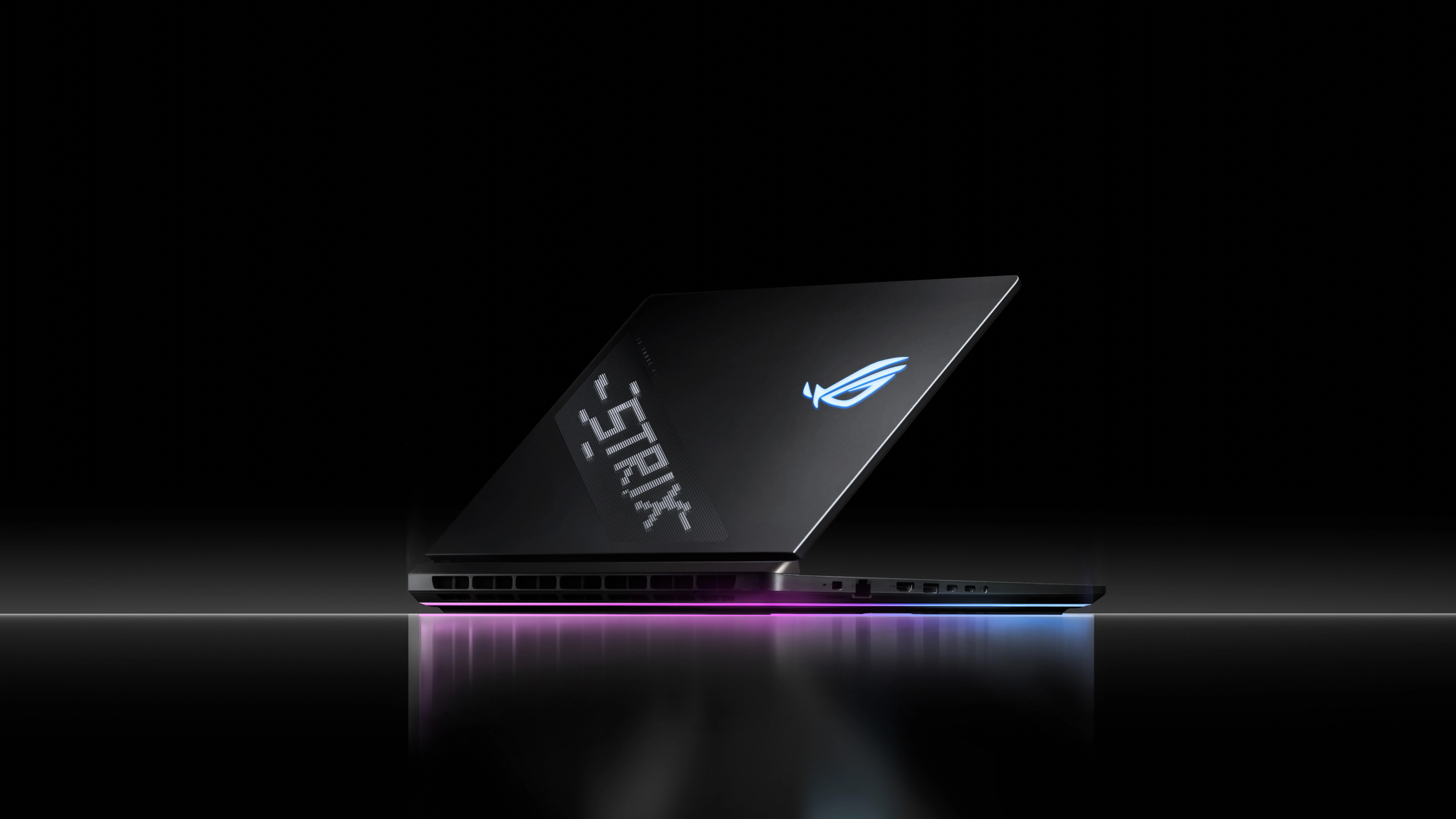 Un laptop Strix așezat pe o suprafață reflectorizantă cu AniMe Vision și Full-surround RGB vizibil
