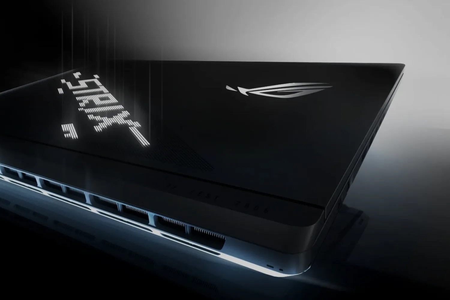 Marginea din spate a unui laptop ROG Strix cu capacul ușor deschis.