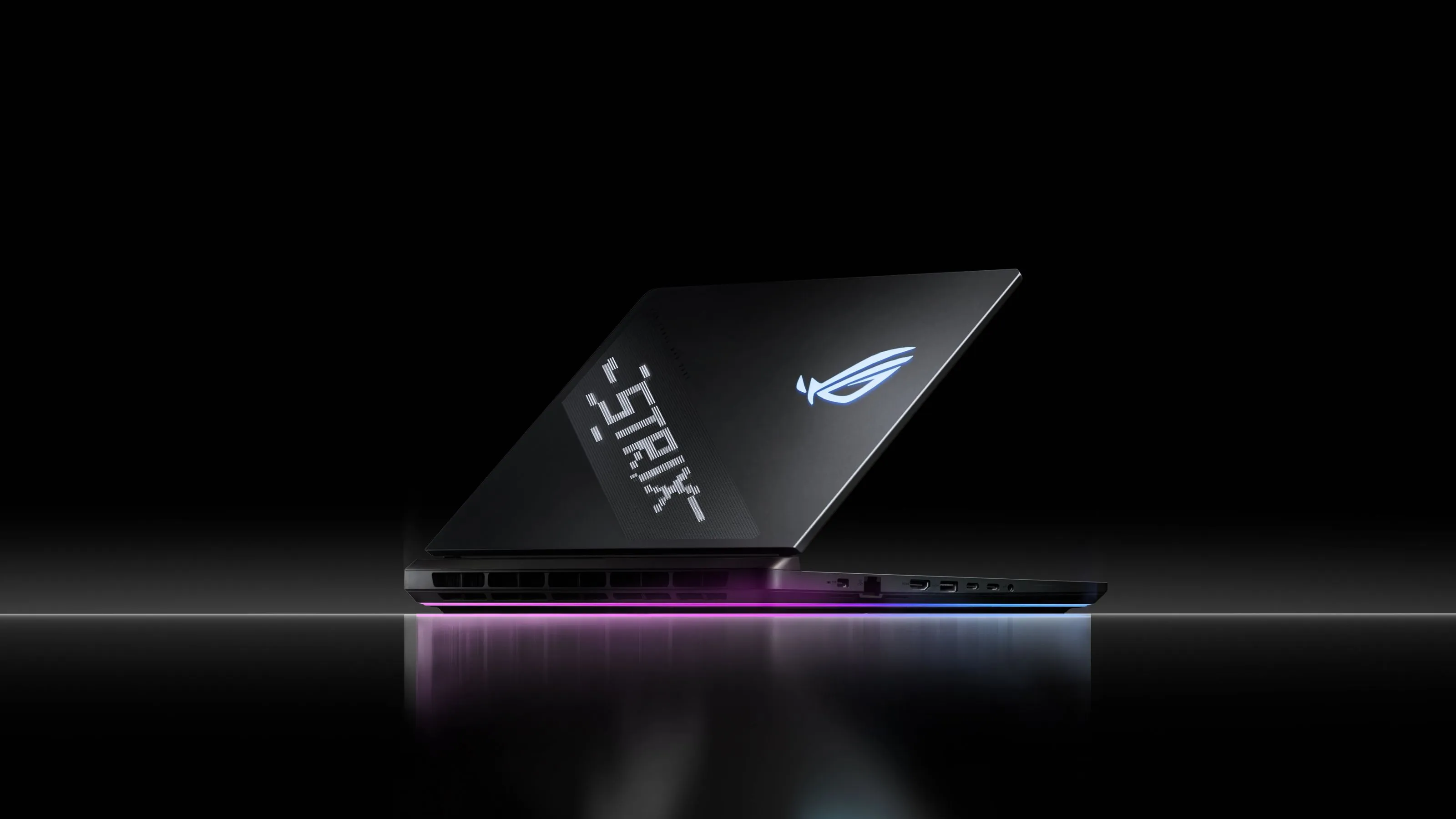Un laptop Strix așezat pe o suprafață reflectorizantă cu AniMe Vision și Full-surround RGB vizibil