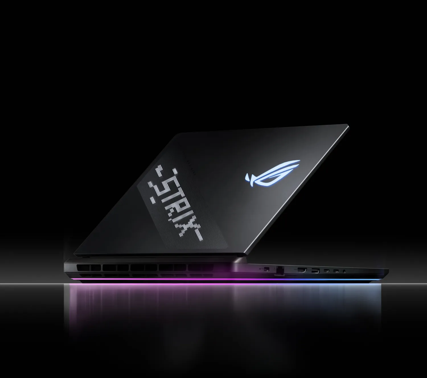 Un laptop Strix așezat pe o suprafață reflectorizantă cu AniMe Vision și Full-surround RGB vizibil
