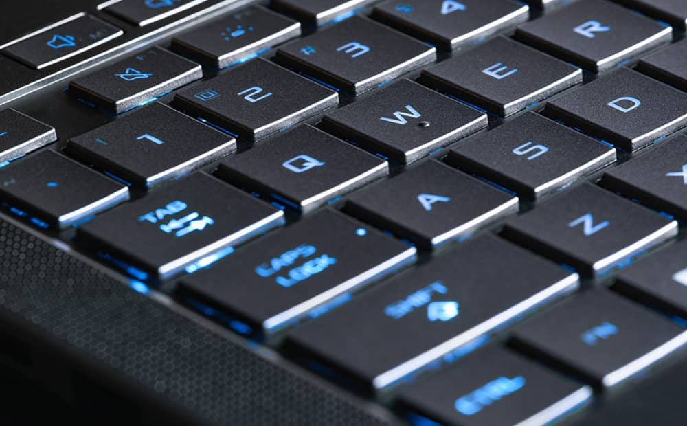 Extreme close up of the WASD keys on the Eclipse Grey Zephyrus G16, with the keys illuminated in blue.