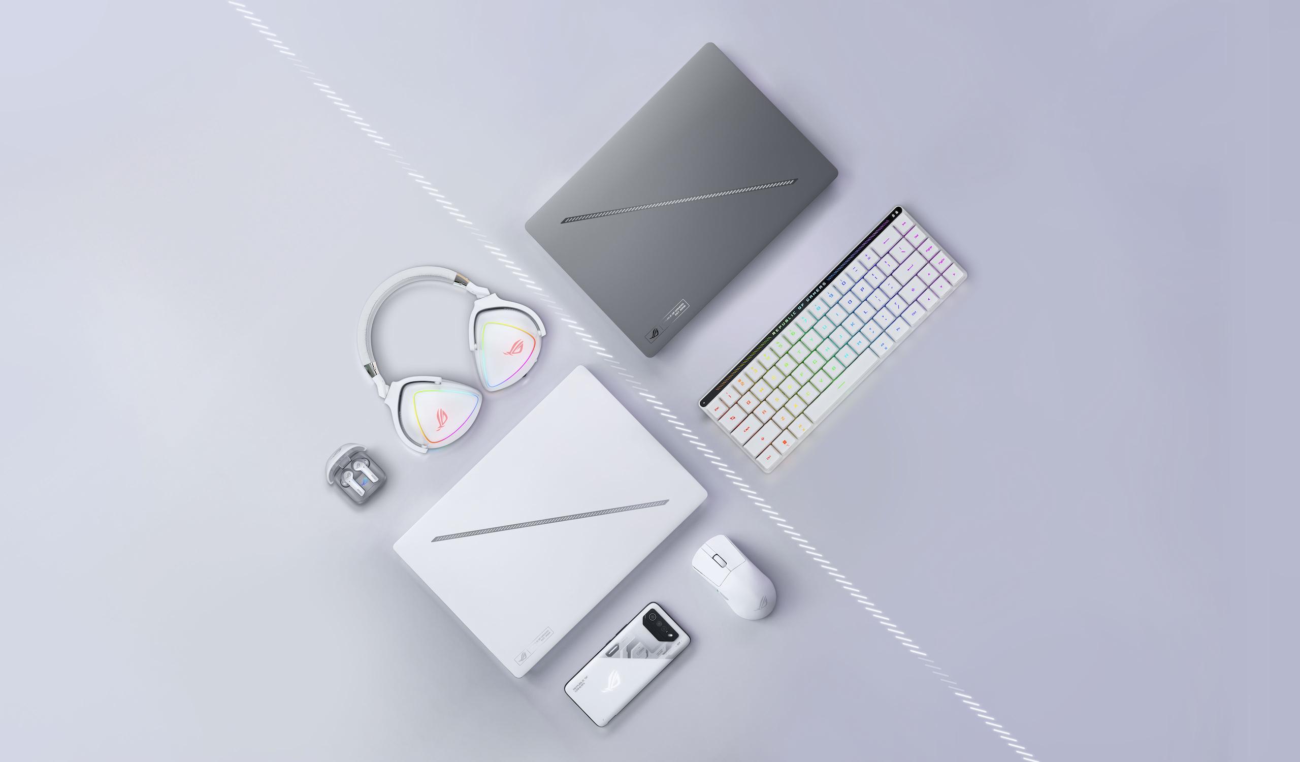 جهاز Zephyrus G14 باللون الأبيض البلاتيني، تم وضعه بالقرب من ماوس ROG وحقيبة الحمل ومحول الطاقة الخاص به.