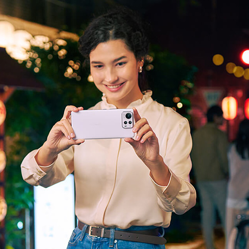a woman is smiling while clicking a pictiure with the Zenfone 12 Ultra.
