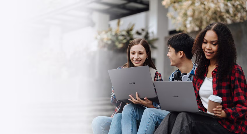 Three students sitting on outdoor steps, smiling and working together on ASUS ExpertBook P3 G2.